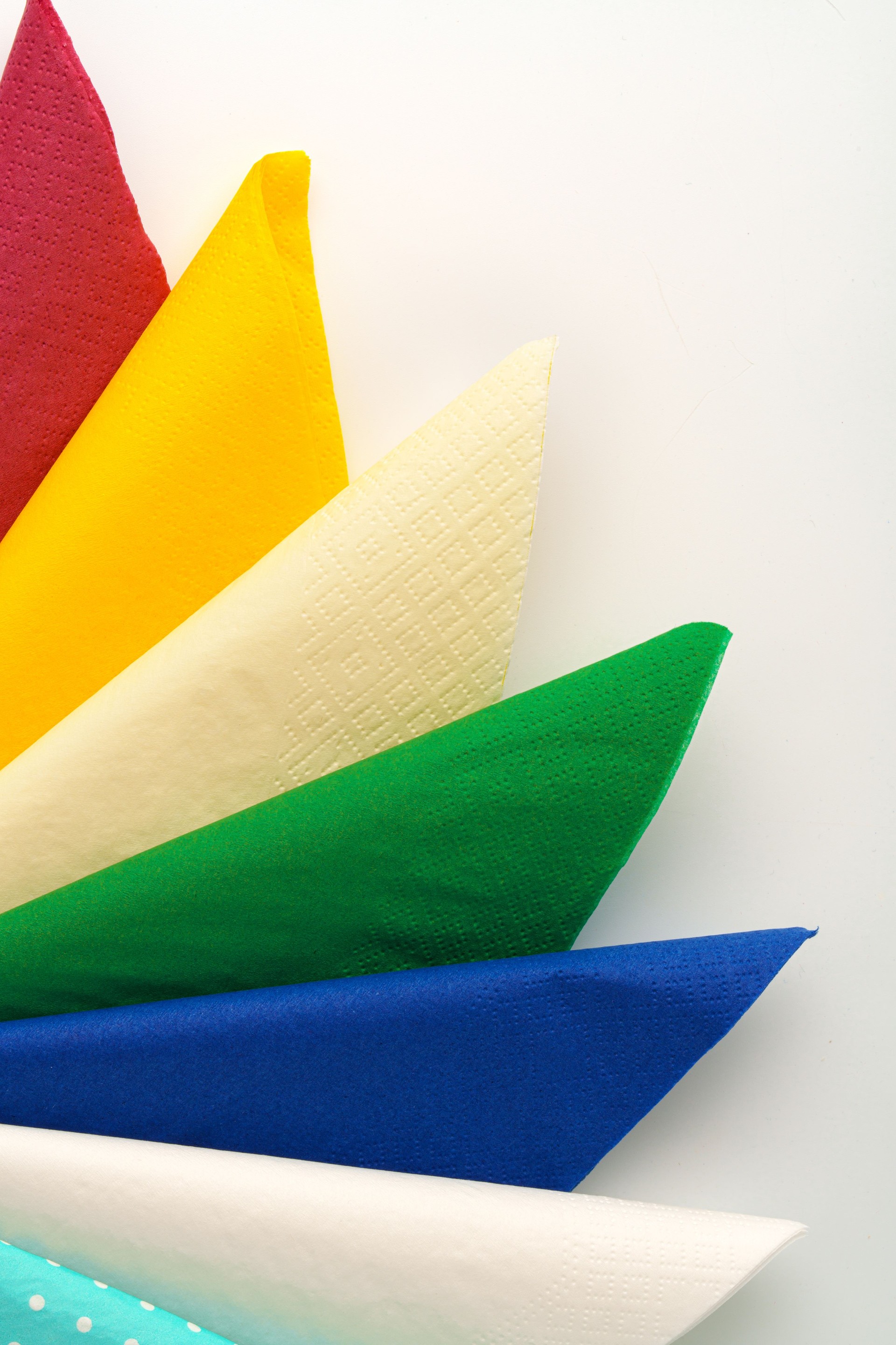 Pila colorida de servilletas de papel sobre fondo blanco